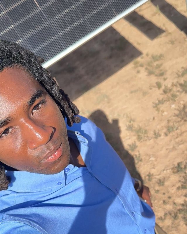 Preston Holmes under a solar panel at a community solar farm